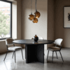 A modern dining room showcases The Avalon Round Dining Table with three beige chairs and a dark vase centerpiece. Five amber pendant lights hang above, while a large window reveals tree and building views. Neutral walls and framed wall art enhance the elegant atmosphere.