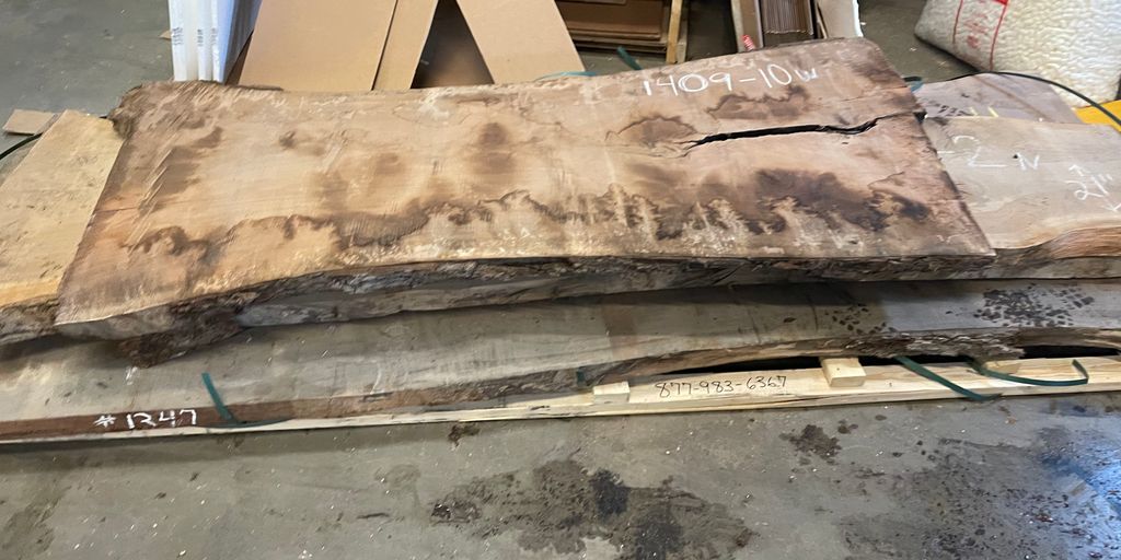 A large wooden slab with visible grain and a crack.