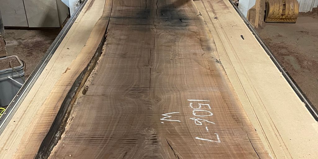 Large wooden slab on a CNC machine in a workshop.