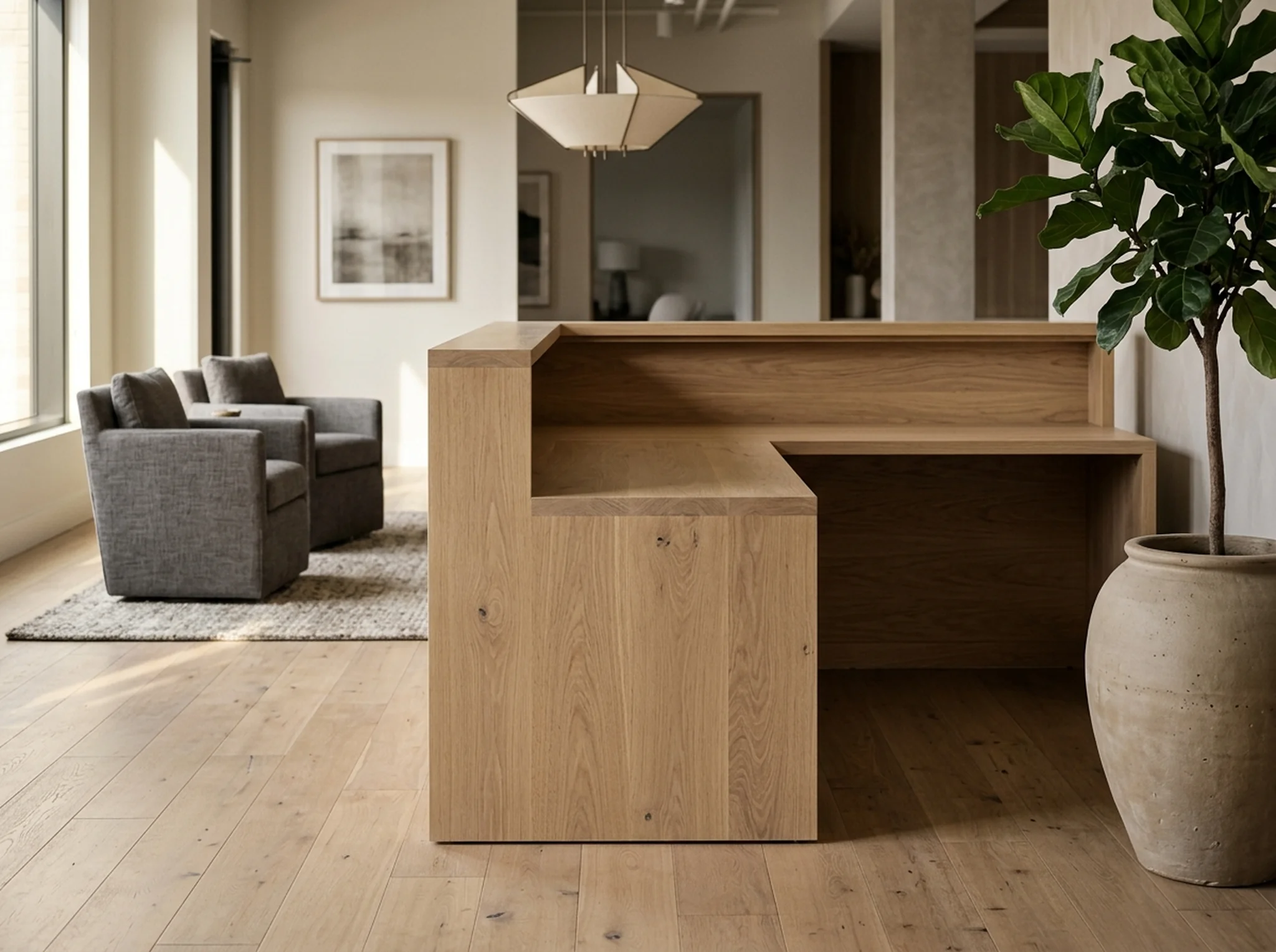 Office reception with a White Oak reception desk and two upholstered guest chairs — Fargo Woodworks